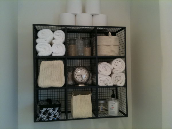 With very limited storage space above the toilet, this storage idea for wire cubes makes a functional display. 