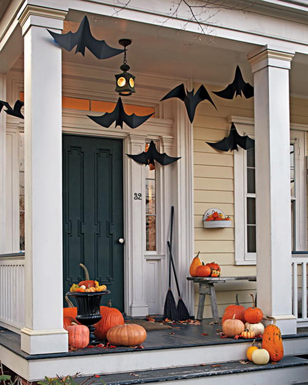 Halloween porch deocration with hanging black bats and witch brooms. 