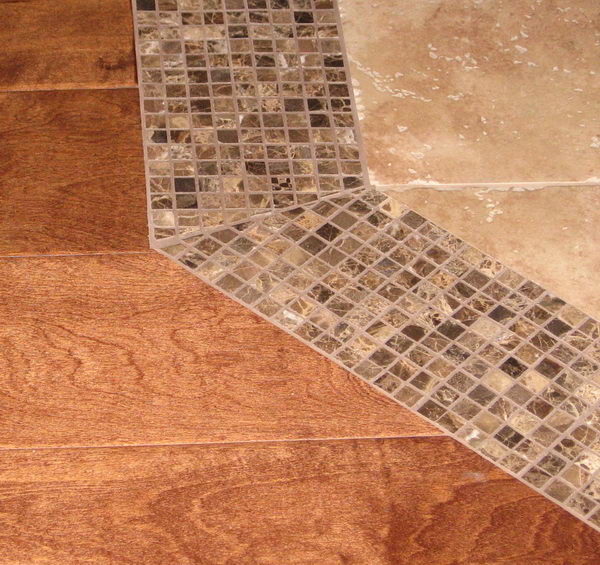 Use smaller tiles as a threshold for the transition from tile to wood. 