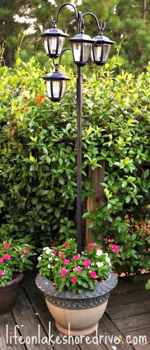 Make a solar light lamppost with flower planters. 