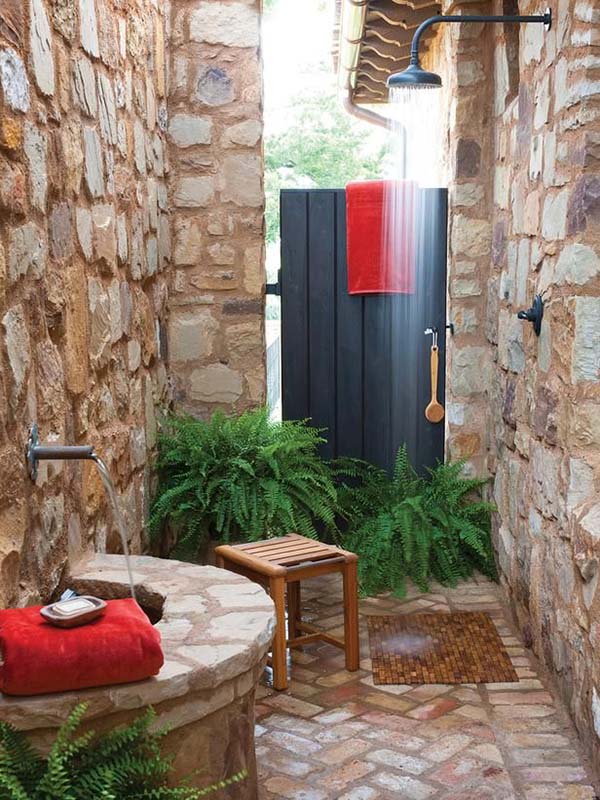 Stone wall outdoor shower with wooden stool. 