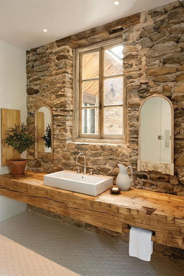 Rustic bathroom with stone walls and wooden wall vanity 