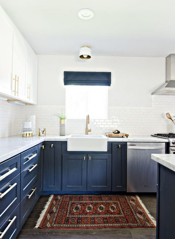 Dark blue and white kitchen cabinets with gold fittings. 