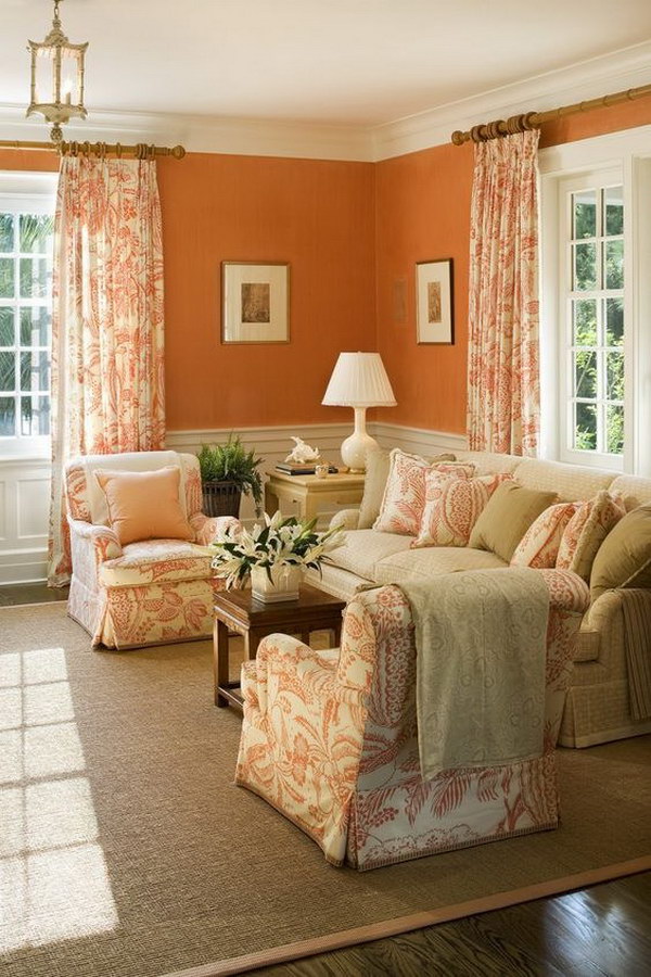 Living room with an orange wall, chairs and curtains. 