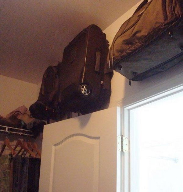 Keep the suitcase on hooks in the room above the cabinet door 