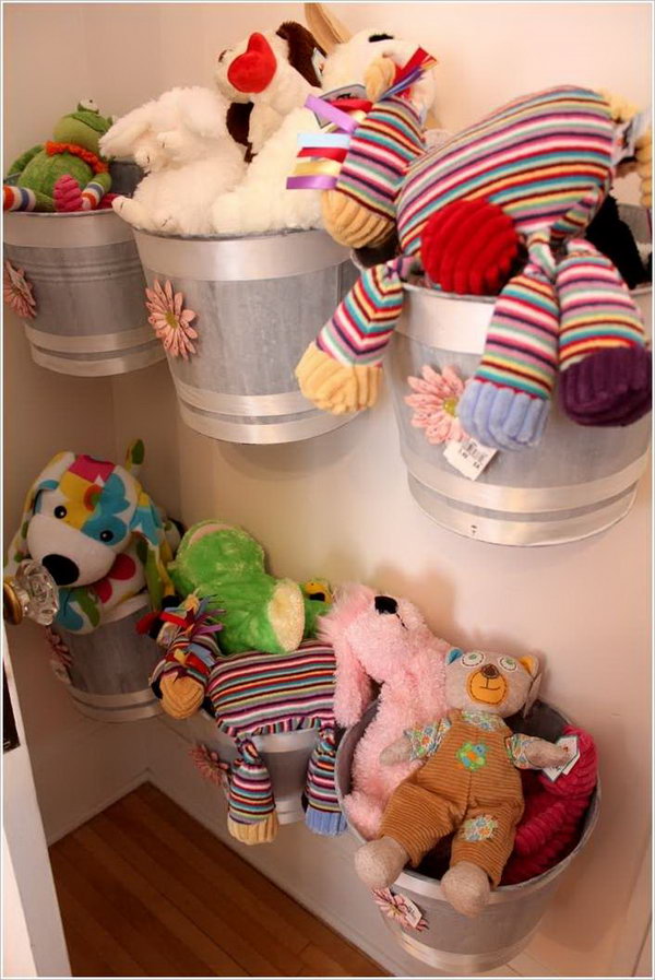Buckets mounted on the wall serve as cute storage for cuddly toys