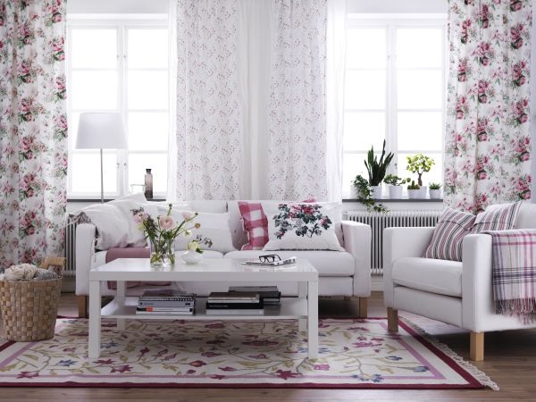 Soft and feminine IKEA living room. White earthy neutral and updated versions of flowers give this living space a fresh and feminine feel. White and soft sofas, white coffee table really match the floral and beautiful curtains.