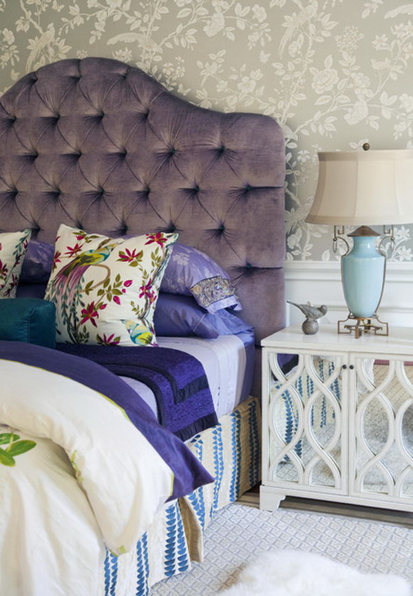     Comfortable luxury: The plush, tufted purple headboard gives this bedroom comfortable luxury. The layered, colorful bedding is an example of how you can inject a more subtle dose of purple. The mirrored bedside table looks chic and elegant.