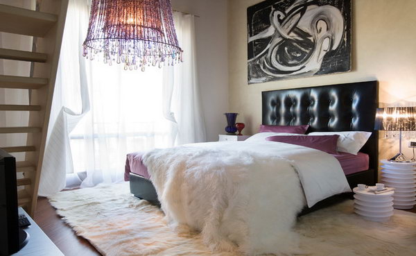     Touches of Purple: This bedroom with a striking chandelier and a leather headboard and the impressive modern wall art looks really rocky. But the artificial animal skins and the purple reflections on the bed linen look warm and soft. Good example for the interpretation of purple in different textures 