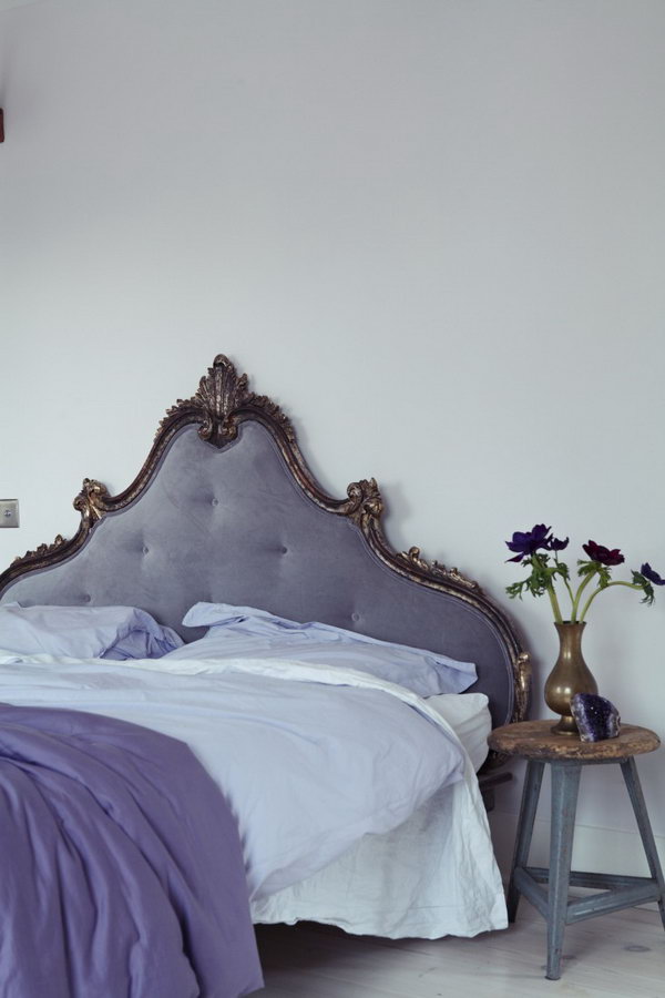 Eye-catching French headboard: In the master bedroom, a French headboard is covered with a soothing purple-gray velvet that blends in well with the white-painted walls of Farrow & Ball Great. 
