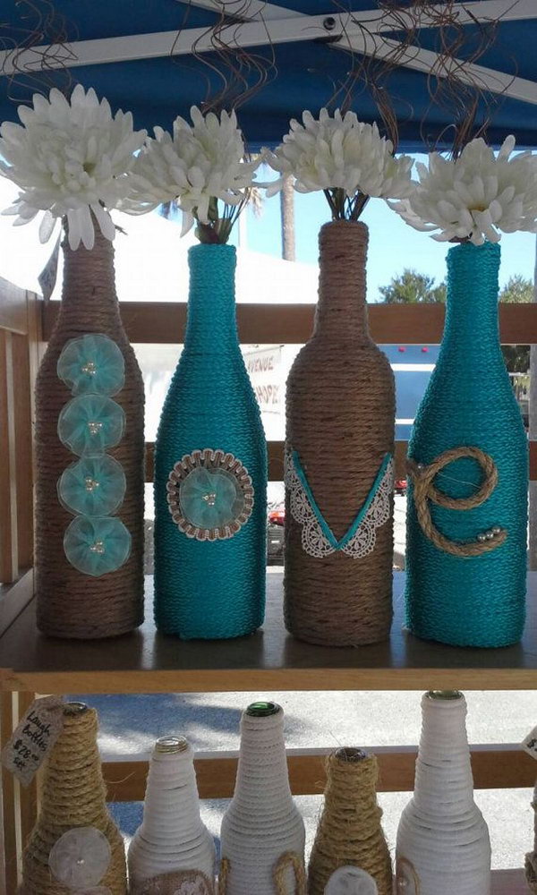 Upcycled rope bottles as a wedding decor. These adorable wine bottles with the letters LOVE wrapped in ropes are wonderful for a wedding with flowers. 