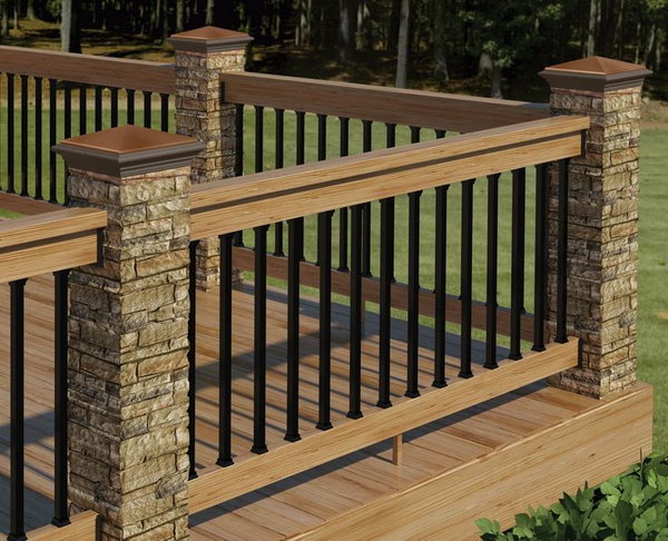 Deck railings made of stone, metal and wood. This railing has a wooden plate with horizontal metal rails and large stone columns and is very robust and low-maintenance. The color theme matches the composite deck perfectly. What an attractive, warm and inviting outdoor living space. 