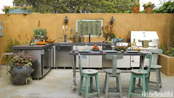 This outdoor kitchen designed by Sandy Koepke in Manhattan Beach, California conveys a feeling of age and maturity. It's really a great place for a party with a stunning outdoor fireplace, earthy cubes, and draft beer. 