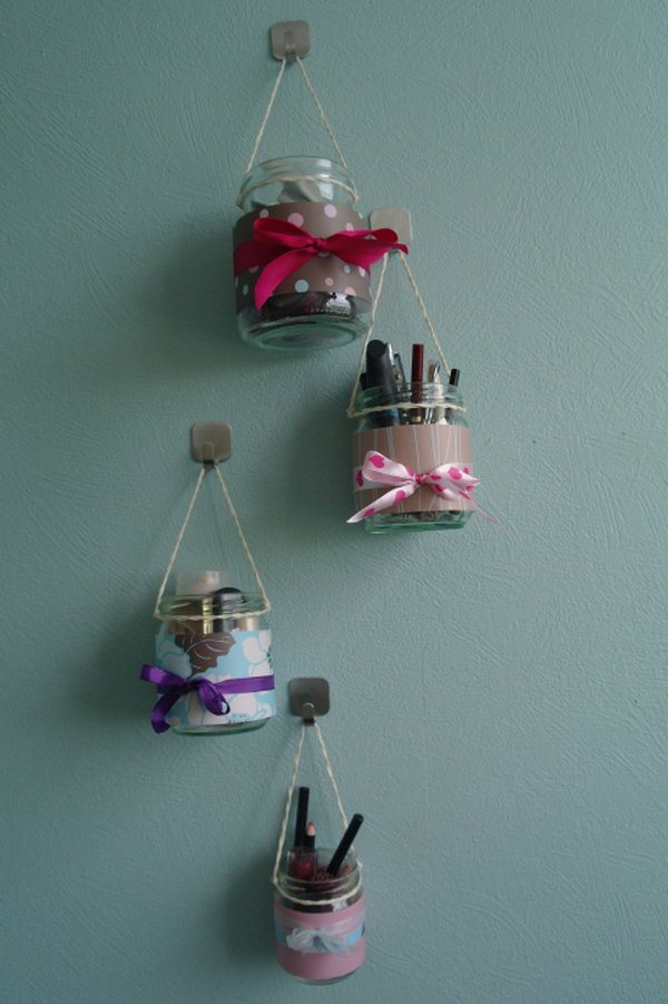Makeup organizer hanging glasses. Decorate the common glasses with beautiful fabrics or colored ribbons and then hang them up with a good number of cords. New hanging makeup kits are born. So simple, but incredibly cute. 