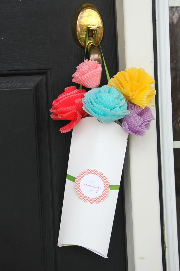 Pillow box bouquet for May. Make colorful flowers of various sizes from the cupcake liner and stick them on the straw. Thread the ribbon through the holes, add the label, and slide the flowers into the box to draw everyone's attention with this beautiful bouquet in May.