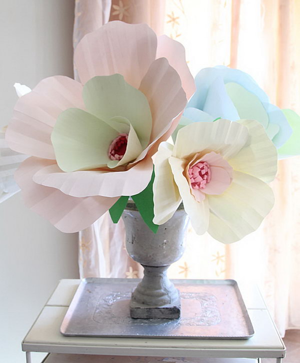 Giant paper bouquet centerpiece. Cut slits into petals by tracing the stencil and assemble it into a cup shape. Arrange the petals and glue them together. Glue the flower and leaves onto the dowel. Everyone will enjoy this brilliant piece of art in May.