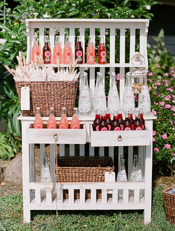 Bookshelf drink station. Serve your drinks in adorable glass bottles. Show them in good order on the bookshelf. This works perfectly for a rustic style.