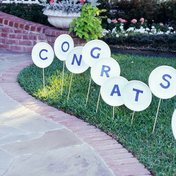 Wood sign graduation ceremony. Use this wooden sign to direct your guests to your front path. Cut letters out of blue paper and stick them on paper plates. Attach wonder dowels and stick in the lawn for an easy graduation party without costing too much.