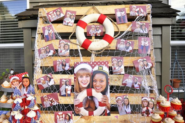 Sail Away graduation ceremony. Use the wooden shipping pallet as a background for the pictures. Cover the tables with a selection of red, white and blue tablecloths. Add the fabric pennant banners to form the fence.