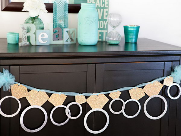 Glittering ring banner. This gorgeous diamond ring banner with its cute view is perfect for a graduation party. Attach each circle to the diamond with tape. Pass the ribbon or tulle through the eyelet to hang and celebrate.