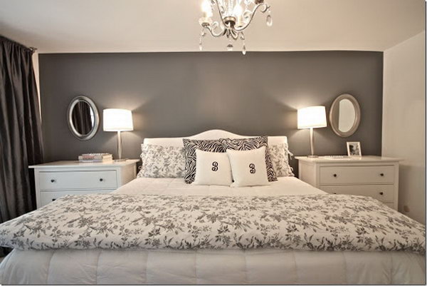This master bedroom looks very nice, big and big with a dark gray accent wall and practical chests instead of small bedside tables.
