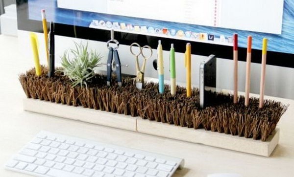 An organized desk gives you an organized spirit and a good mood. So get yours in order by simply turning a broom head over to store most of the garbage on your tabletop like pens and office supplies, and even creating a cool charging dock for you smartphone. 