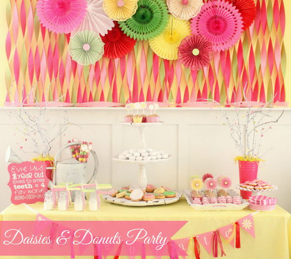 Daisies and donuts party idea. So many girls dream of a party with a sweet and fresh taste. This daisy and donut party will make the princess' dream come true with her accordion fans and tissue fan backdrop, a giant tiered stand with a range of donuts and cookies to top off her sweet and beautiful view.