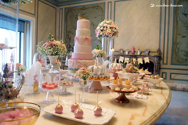 Gorgeous princess birthday party. The beautiful six-tier princess cake is really breathtaking with the beautiful floral arrangements that surround it. The sweet, gold and pink colored, ruffled cake balls, the stacked mini cakes with golden crowns and the gift boxes patterned with lace give the party spread section a more elegant meaning. Seriously spectacular for such an event.