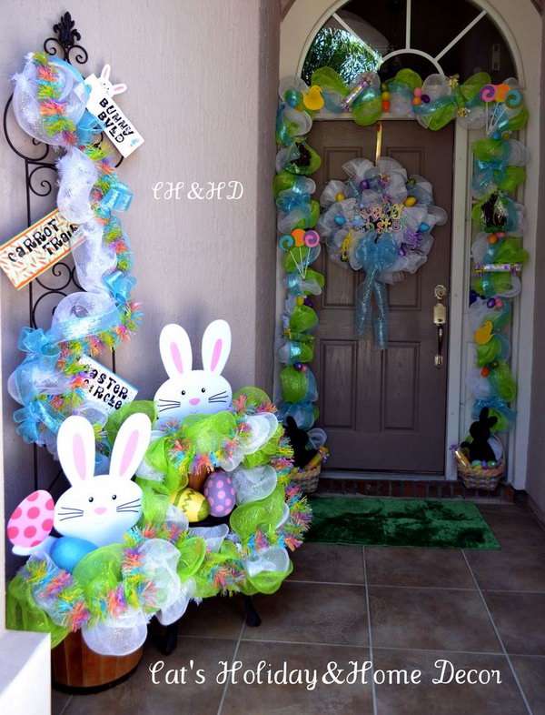 Easter basket door decor. This sophisticated Easter decor begins with a mesh in white and lime green. Add the ribbons as a base. Place two baskets of children's treats on two sides, like chocolate bunnies, rolled candy, Easter eggs, and gummy bears.