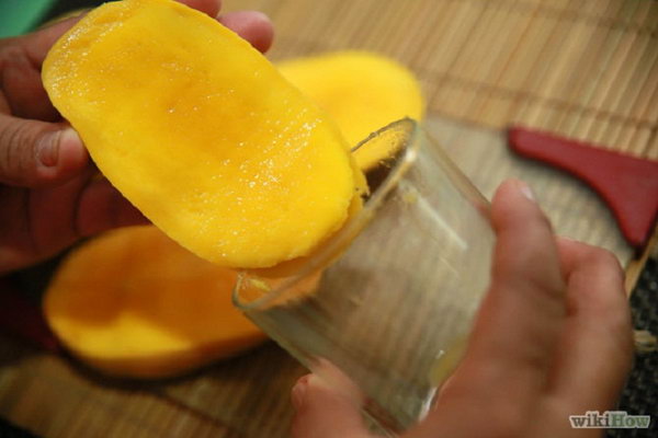 Peel a mango with a drinking glass edge. The best way to peel a mango. It can be done in just a few seconds with no problems.