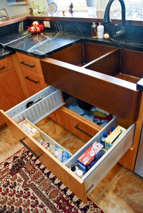 Sink drawer surround plumbing. The sink drawer is adjustable in such a way that it fits around the pipes and waste disposal underneath. It's a great place for all the sponges, dish soap, trash bags and cleaning supplies that are normally lost in the dark corners. 