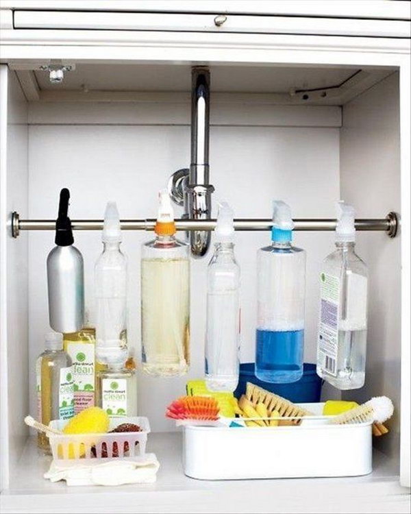 Hang the spray bottles under the sink. Install a curtain rod over the cabinet. Hang the spray bottles on their spray triggers and create storage space for bathroom or kitchen utensils. 