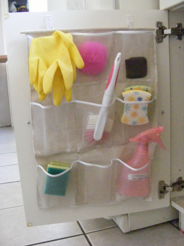 Cut a large shoe organizer in half and use it on each side of the base cabinet. It is a perfect solution for holding sponges, brushes and other cleaning agents. 