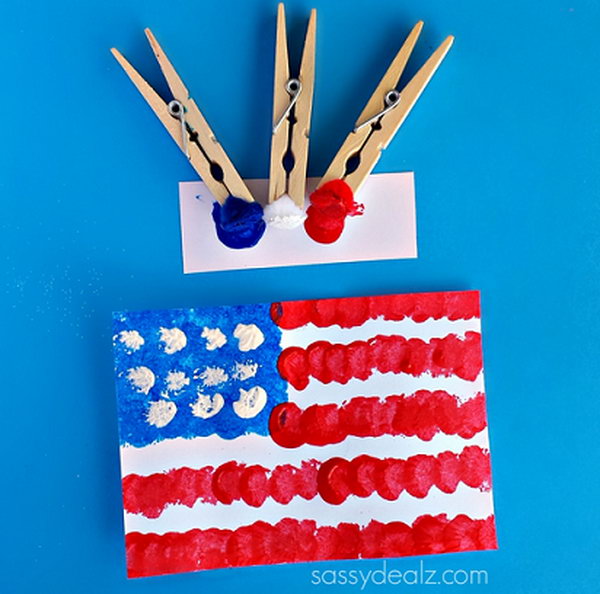 Pom-Pom American Flag painting craft for kids. Sometimes using a regular brush can get boring. So use clothespins and pom poms to make a cool American flag craft. This is fun and easy for children to do on July 4th or on the anniversary. 