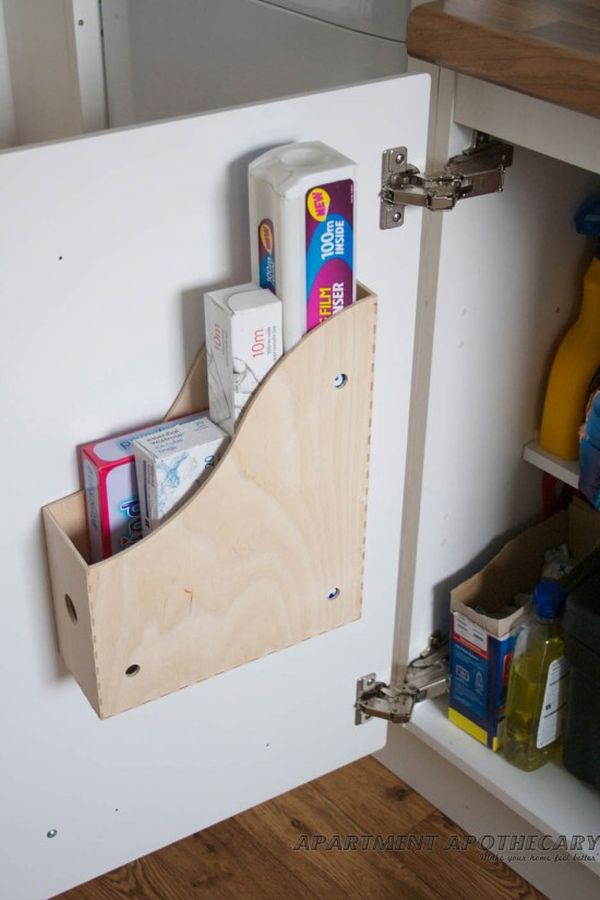 Attaching a magazine holder to the inside of kitchen cabinets gives you extra space for bulky items such as cutting boards, cleaning supplies, etc. 