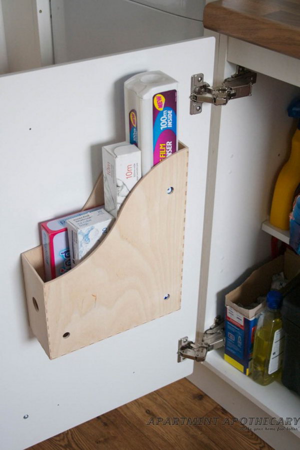 Screwing a magazine file holder onto the inside of kitchen cabinets creates space for bulky items such as cutting boards, cleaning agents, etc. 