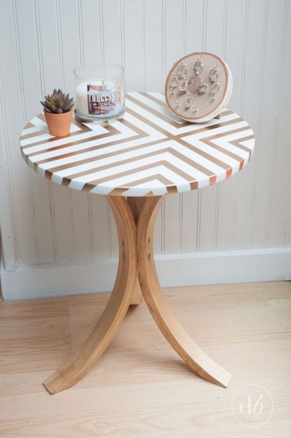 Takes an old Ikea table and gives it a beautiful and trendy side table with tape, gold spray paint and wood stain. 