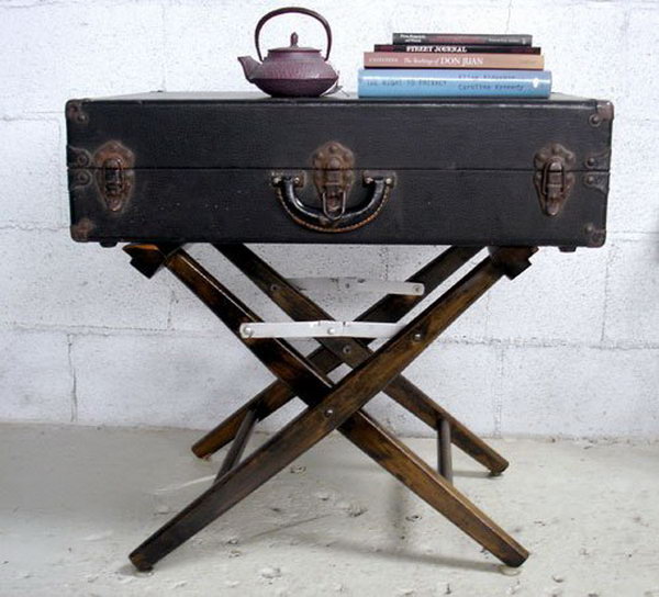 DIY side table consisting of a damaged canvas folding chair and a vintage suitcase.