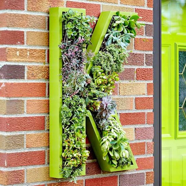 Living monogram wreath. It allows plants to extend upwards instead of growing along the surface of the garden. Doesn't take up much space and looks so beautiful at the same time.