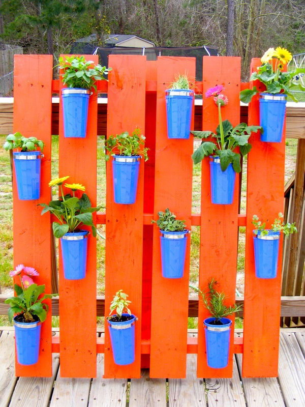 Pallet herb garden using dollar storage cups. It allows plants to extend upwards instead of growing along the surface of the garden. Doesn't take up much space and looks so beautiful at the same time.
