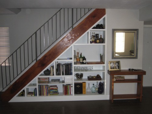 Bookcase under the stairs. The space under a staircase can be used to clear everyday clutter.