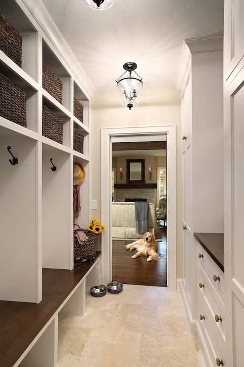Awesome mudroom with limestone tiled floors and built-in cubbies .