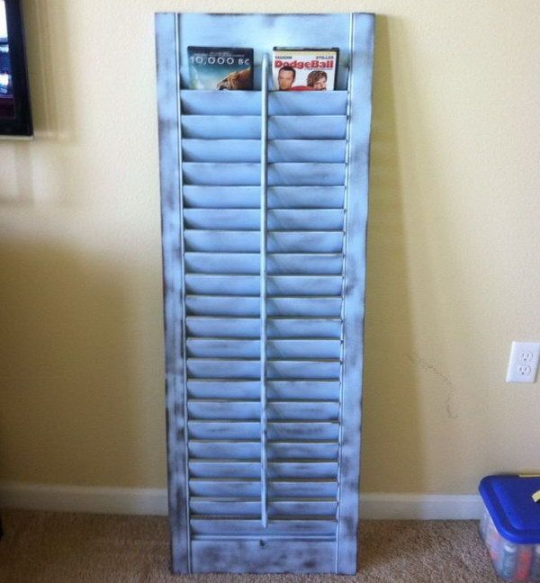 This old shutter was painted and repurposed to be a DVD holder .