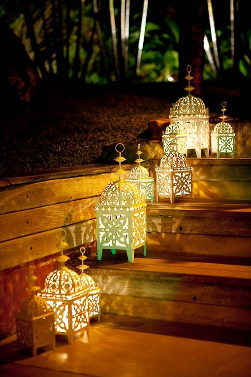 A cute set of simple Moroccan lanterns used outdoors in a garden .