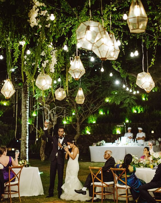 Picture Of geo lanterns glowing in greenery for an outdoor weddi