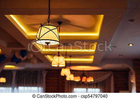 Vintage retro chandeliers with luminous lamps hanging on the ceilin