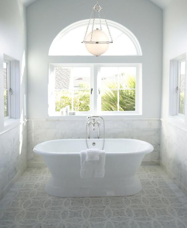 Stunning bathroom features vaulted ceiling accented with sphere .
